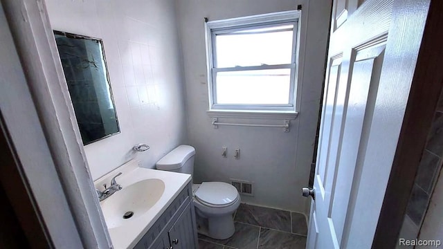 full bathroom with vanity, toilet, and visible vents