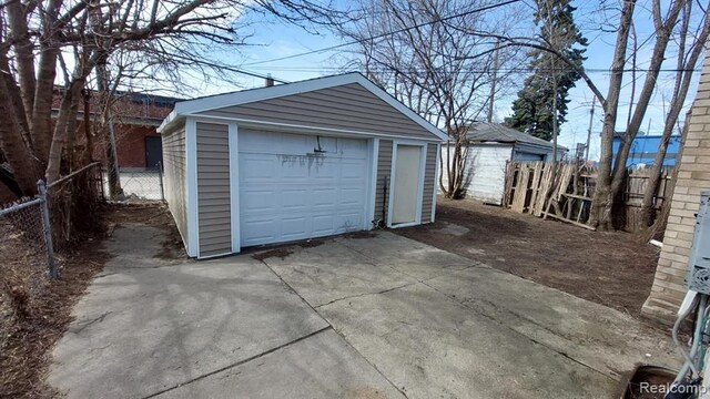 detached garage with fence and driveway