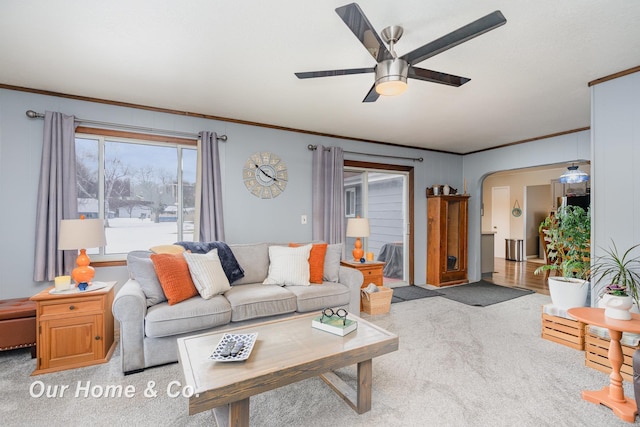 living room featuring ornamental molding, light colored carpet, and ceiling fan