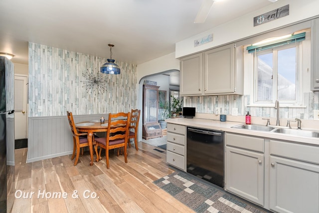 kitchen with gray cabinets, pendant lighting, dishwasher, sink, and light hardwood / wood-style flooring