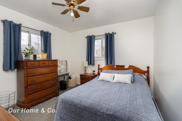 carpeted bedroom featuring ceiling fan and multiple windows