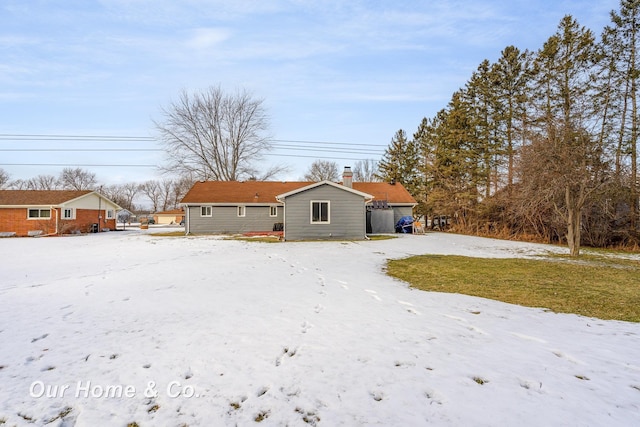 view of snow covered rear of property