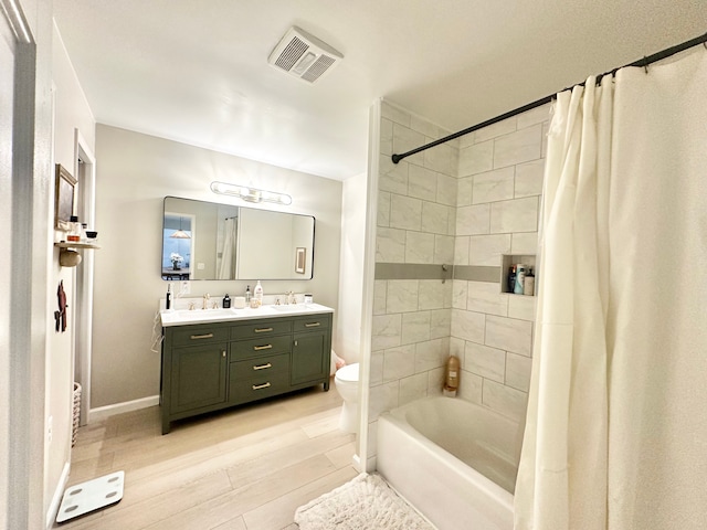 full bathroom with vanity, hardwood / wood-style floors, shower / bath combo, and toilet