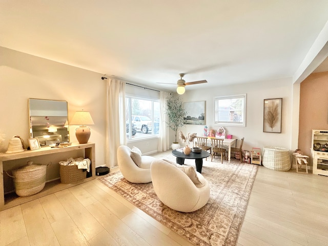 living area featuring hardwood / wood-style floors and ceiling fan