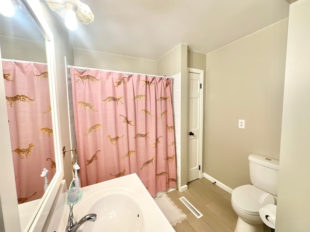 bathroom with sink, hardwood / wood-style flooring, and toilet