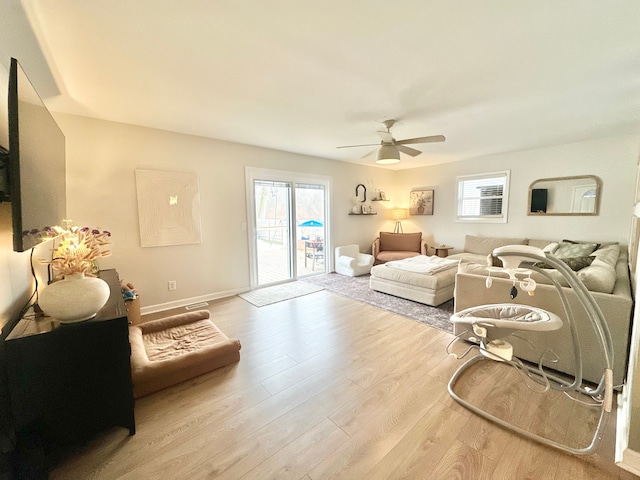 living room with ceiling fan and light hardwood / wood-style flooring