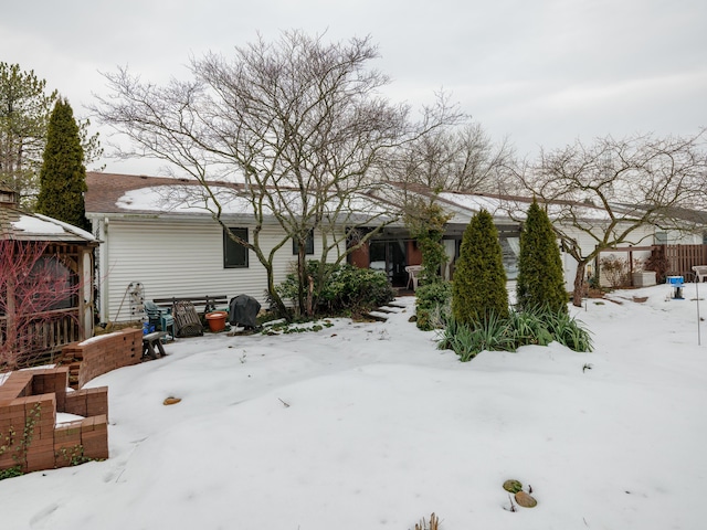 view of snow covered back of property