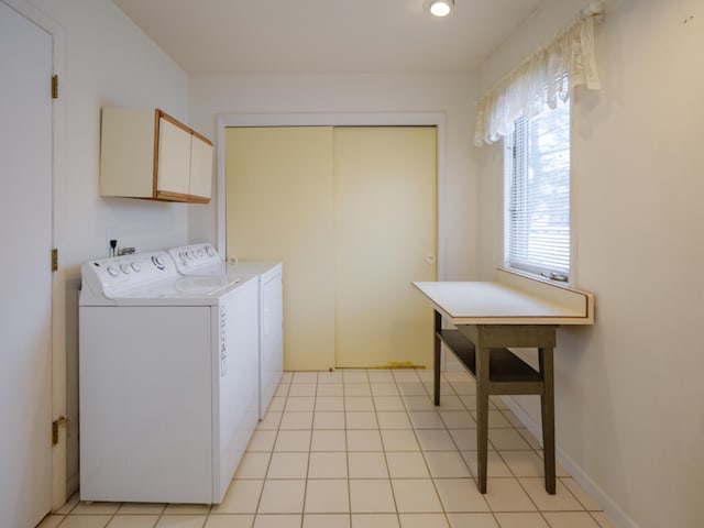 laundry room with light tile patterned floors, washing machine and dryer, and cabinets