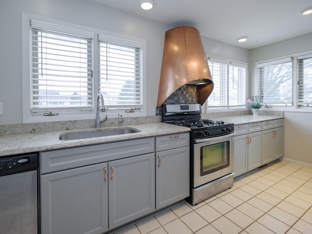 kitchen featuring island range hood, sink, gray cabinetry, light stone counters, and stainless steel appliances