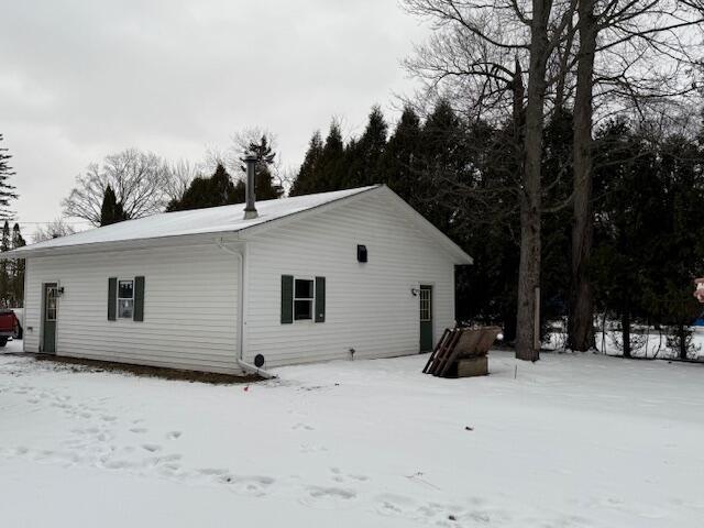 view of snow covered rear of property