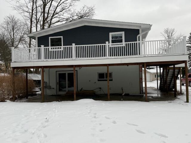 snow covered property featuring a wooden deck