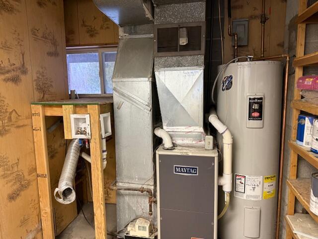 utility room featuring water heater and heating unit