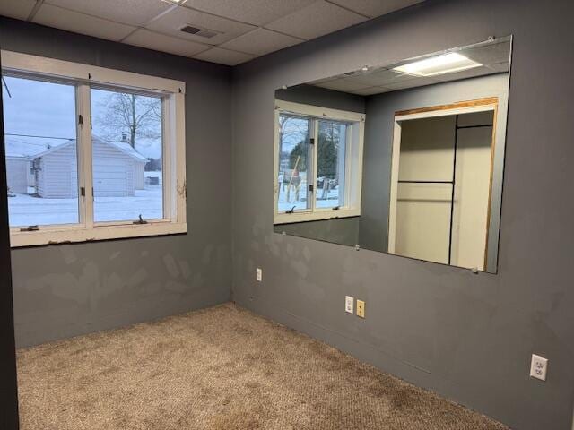 empty room with light carpet and a paneled ceiling