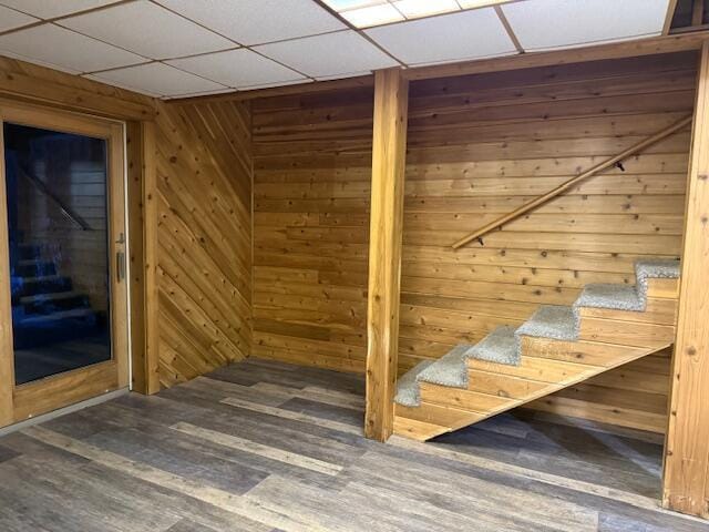 additional living space featuring wood-type flooring and wooden walls