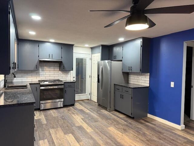 kitchen featuring sink, ceiling fan, appliances with stainless steel finishes, tasteful backsplash, and dark hardwood / wood-style flooring