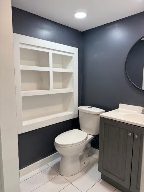 bathroom featuring vanity, tile patterned floors, and toilet