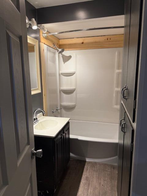 bathroom featuring wood-type flooring, bathing tub / shower combination, and vanity