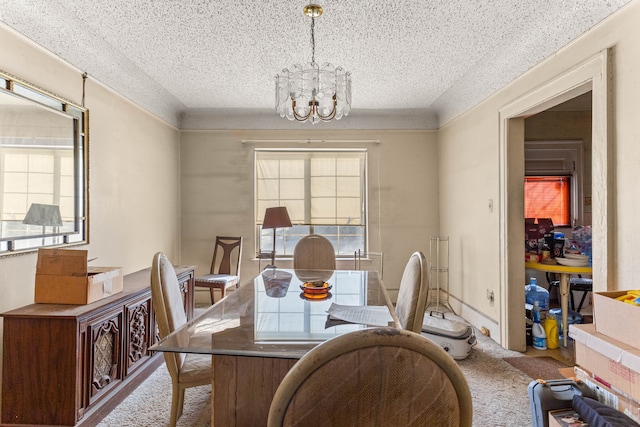 dining space with light carpet, a textured ceiling, plenty of natural light, and a chandelier