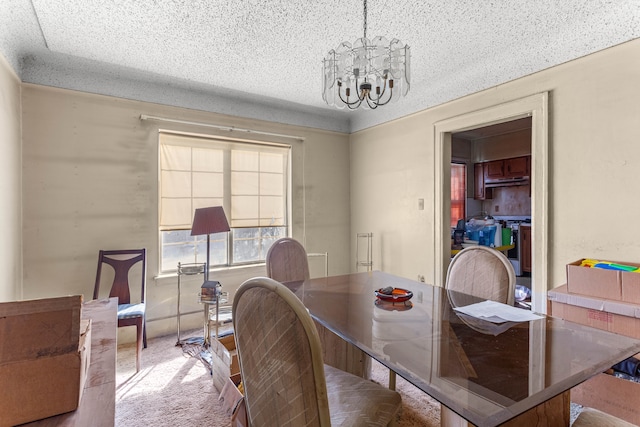 dining space with a textured ceiling, carpet, and a notable chandelier