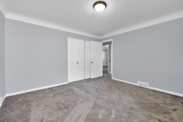 unfurnished bedroom with carpet and a closet