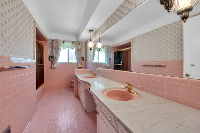 bathroom featuring walk in shower, toilet, tile walls, vanity, and tile patterned flooring