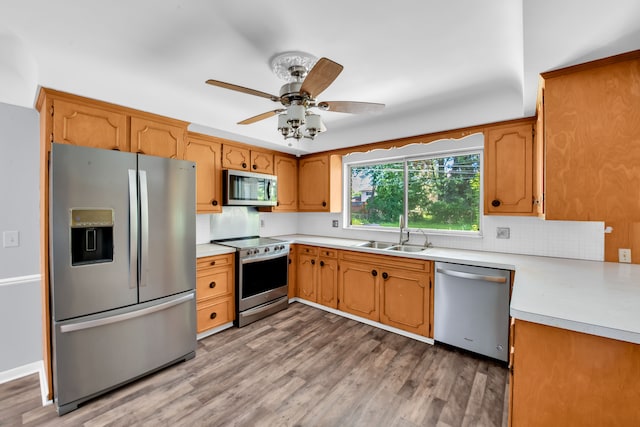 kitchen featuring tasteful backsplash, sink, stainless steel appliances, and light wood-type flooring