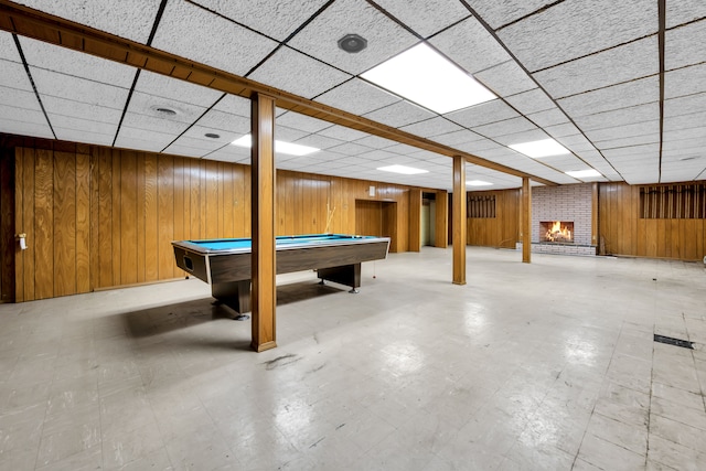 playroom featuring a brick fireplace, wooden walls, and billiards