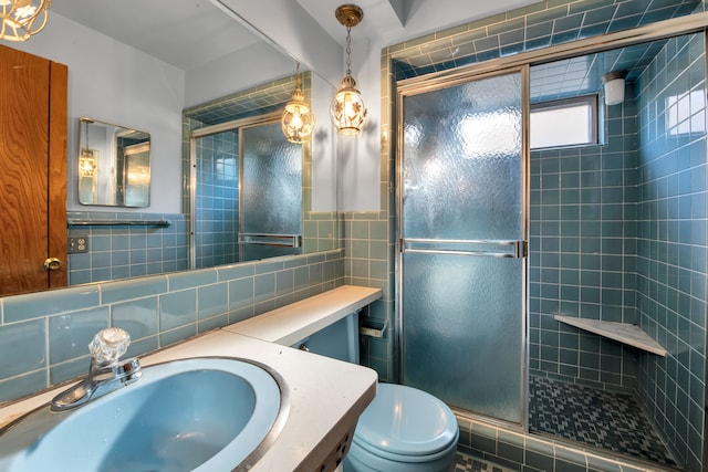 bathroom with vanity, toilet, an enclosed shower, and tile walls