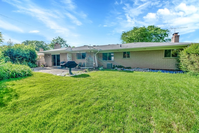 back of house with a yard, central AC unit, and a patio area