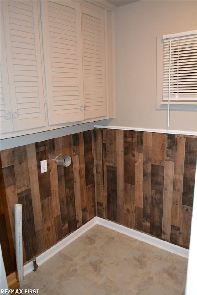 laundry area featuring wooden walls