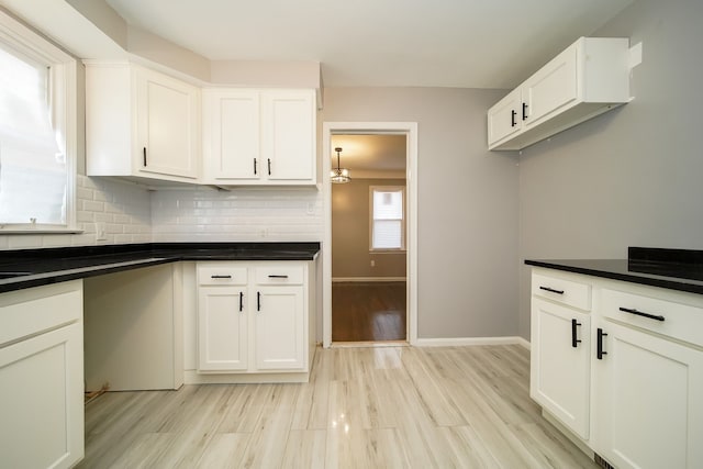 kitchen with white cabinetry, decorative backsplash, and light hardwood / wood-style floors