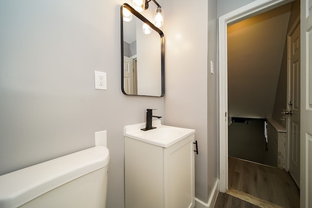 bathroom with hardwood / wood-style flooring, vanity, and toilet