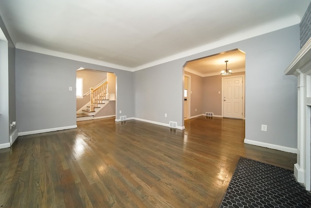 empty room featuring dark hardwood / wood-style flooring and a notable chandelier