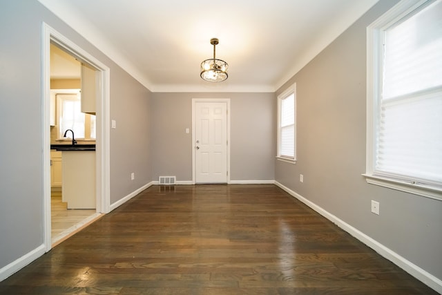 entryway with an inviting chandelier and dark hardwood / wood-style flooring