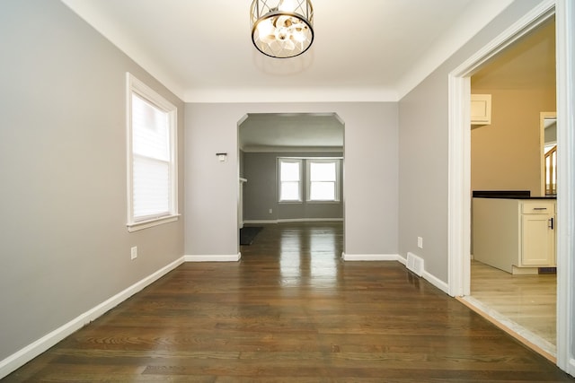 interior space featuring dark wood-type flooring and a chandelier