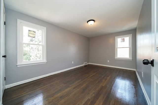 empty room featuring dark hardwood / wood-style flooring