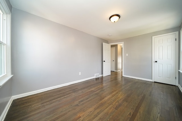 unfurnished bedroom with dark wood-type flooring