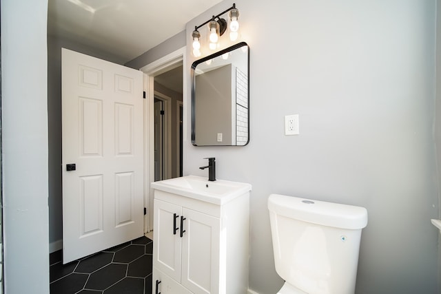 bathroom featuring vanity, tile patterned floors, and toilet