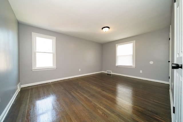 unfurnished room with dark wood-type flooring