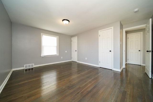 unfurnished room with dark hardwood / wood-style flooring