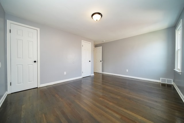 unfurnished room featuring dark wood-type flooring