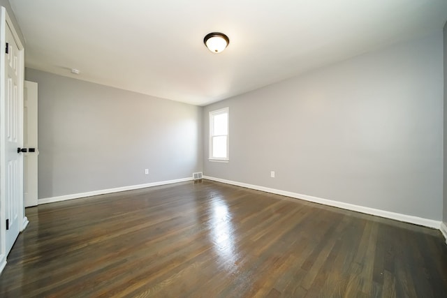 unfurnished room with dark hardwood / wood-style flooring