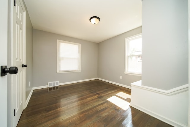 unfurnished room with dark hardwood / wood-style flooring