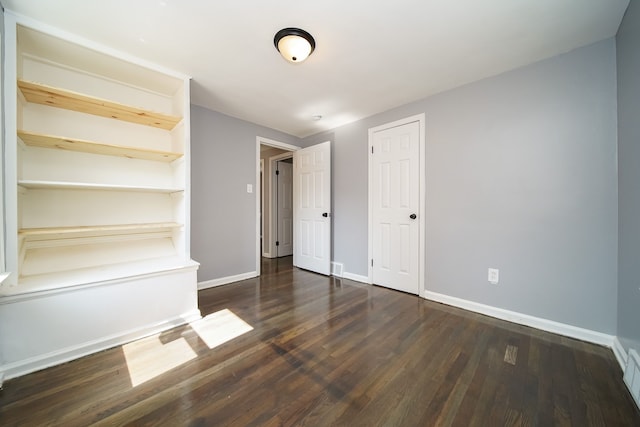 unfurnished bedroom featuring dark wood-type flooring and a closet