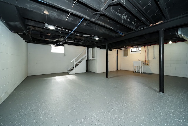 basement with sink, plenty of natural light, and electric panel