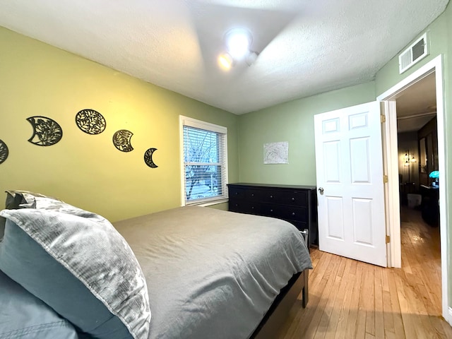 bedroom with hardwood / wood-style flooring and a textured ceiling