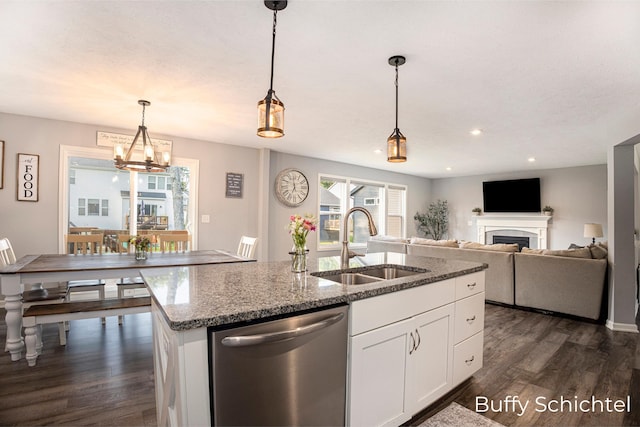 kitchen with pendant lighting, dishwasher, white cabinetry, an island with sink, and stone countertops