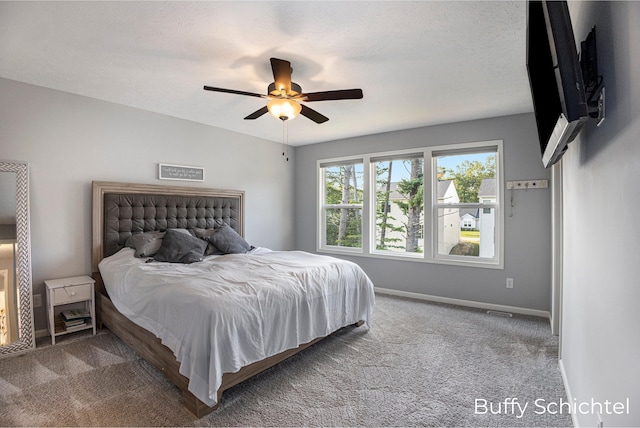 carpeted bedroom with a textured ceiling and ceiling fan