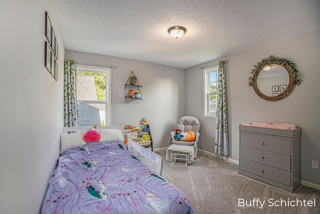 bedroom with multiple windows, carpet floors, and a textured ceiling