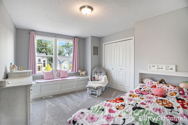 bedroom featuring light carpet, a textured ceiling, and a closet